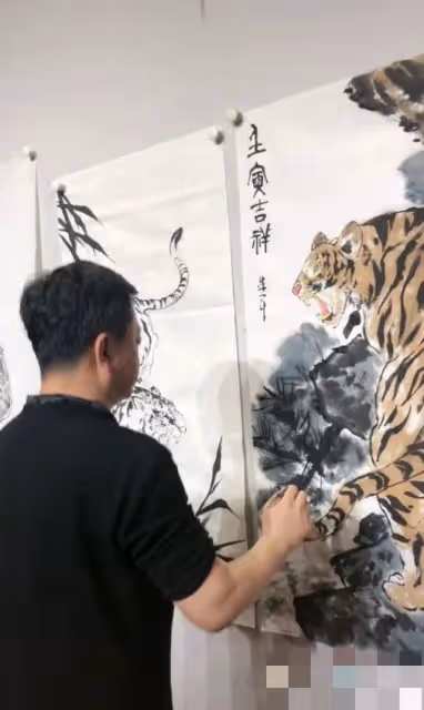57歲朱軍罕露面,過年跪地畫虎有雅興,嬌妻點贊評論盼其再上春晚