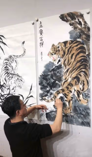 57歲朱軍罕露面,過年跪地畫虎有雅興,嬌妻點贊評論盼其再上春晚