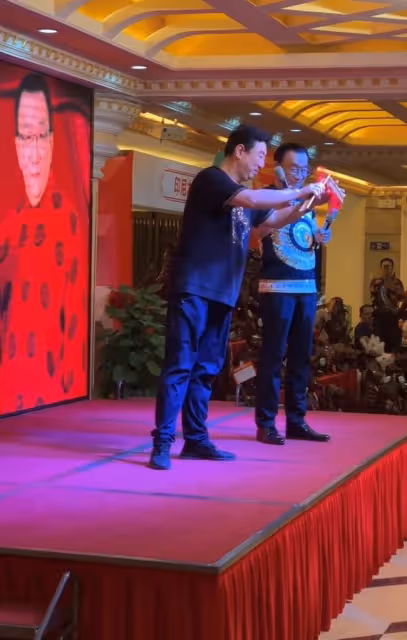 75歲侯耀華現身商演,舉倆話筒為他人當人體支架,抿嘴微笑顯尷尬