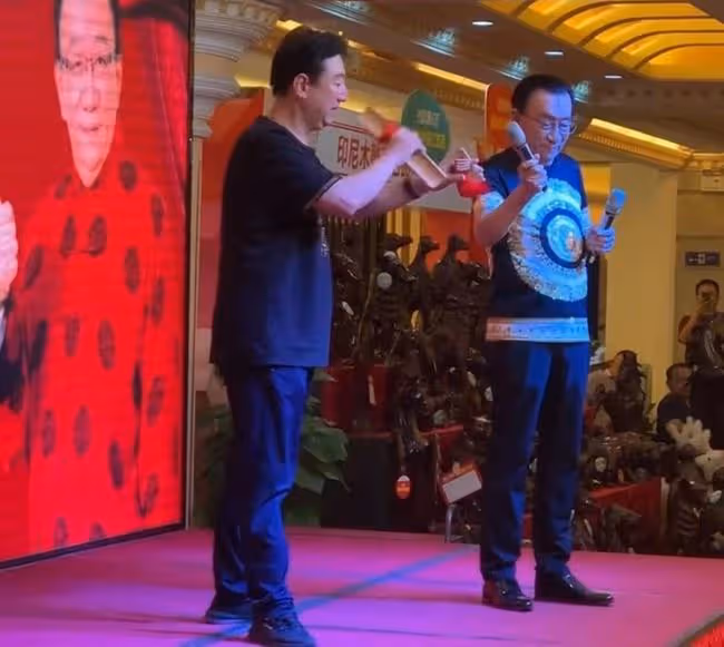 75歲侯耀華現身商演,舉倆話筒為他人當人體支架,抿嘴微笑顯尷尬
