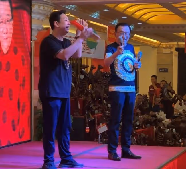 75歲侯耀華現身商演,舉倆話筒為他人當人體支架,抿嘴微笑顯尷尬