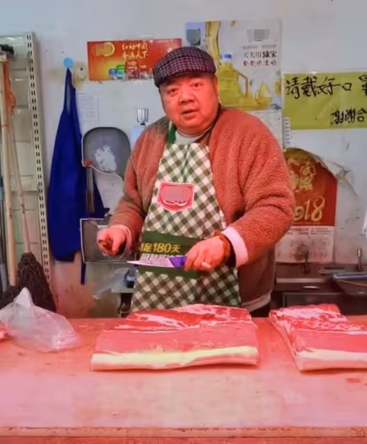 48歲戲骨謝寧菜場賣豬肉,攬客切肉動作嫻熟,攤位環境雜亂接地氣