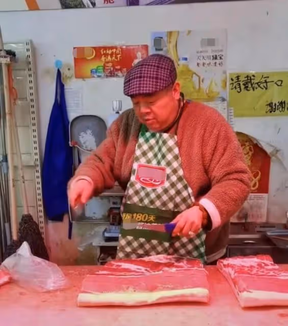 48歲戲骨謝寧菜場賣豬肉,攬客切肉動作嫻熟,攤位環境雜亂接地氣