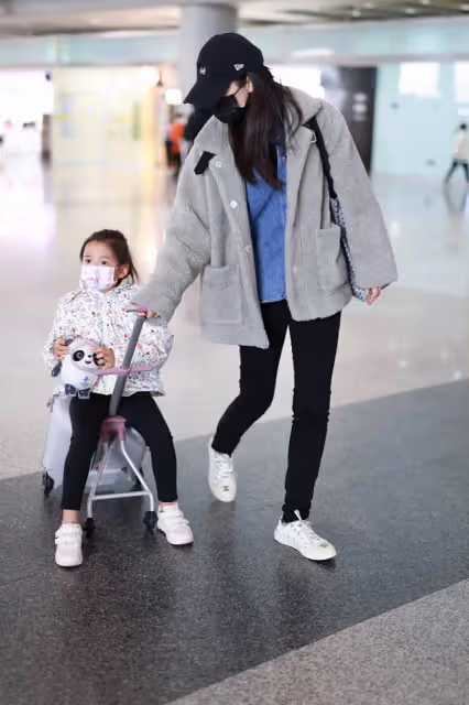 董璇和女兒度假回來現身機場，小酒窩抱冰墩墩萌態十足，超有靈氣