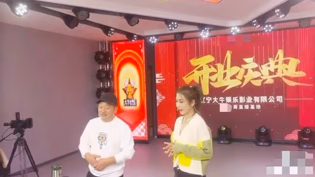 趙本山24歲兒子新公司開業，現場布置簡陋，站謝廣坤身後神情木訥