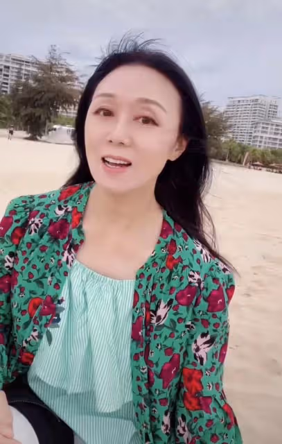 60歲吳瓊曬照意外遭網暴!穿紅戴綠在海邊開心歌舞,被批不合時宜