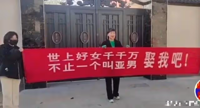 這村人真不消停,大衣哥家門口遭女子扯橫幅,喊話朱曉偉:娶我吧