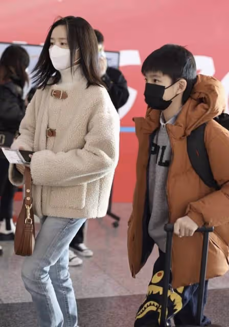 41歲董潔帶娃現身機場,穿四萬外套顯闊氣,12歲兒子眉眼似潘粵明