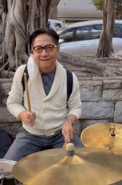 69歲港星跨年現身街頭打鼓!坐樹下背包隨地放,鮮有人圍觀接地氣