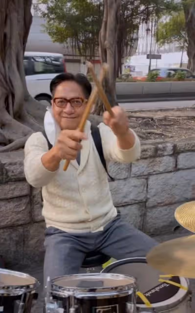 69歲港星跨年現身街頭打鼓!坐樹下背包隨地放,鮮有人圍觀接地氣