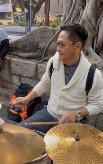 69歲港星跨年現身街頭打鼓!坐樹下背包隨地放,鮮有人圍觀接地氣