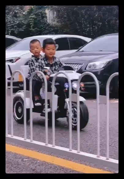 嘎子哥又惹爭議，讓倆娃在馬路上開玩具車，前方十字路口人群密集