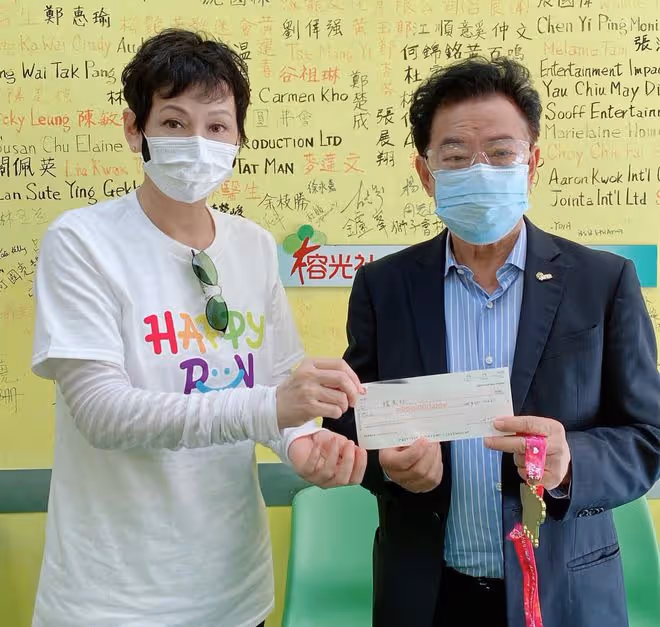 周潤發前妻當志願者,街頭派免費盒飯給老人家,低頭彎腰顯恭敬
