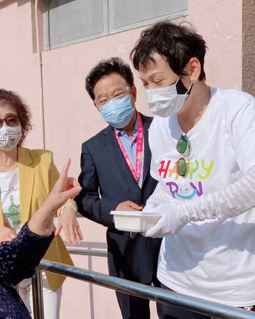周潤發前妻當志願者,街頭派免費盒飯給老人家,低頭彎腰顯恭敬