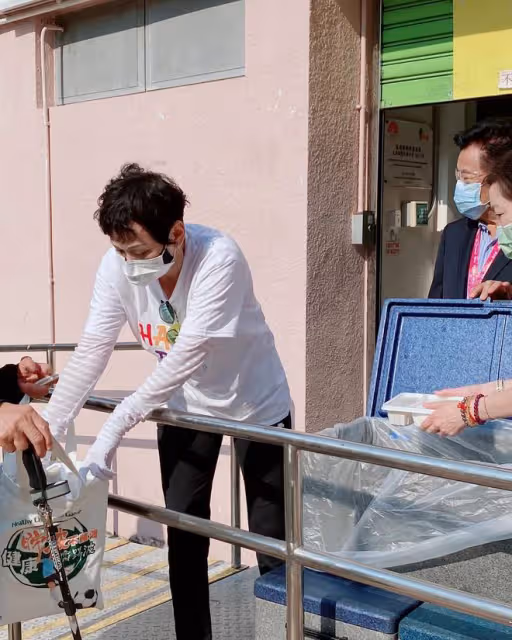 周潤發前妻當志願者,街頭派免費盒飯給老人家,低頭彎腰顯恭敬
