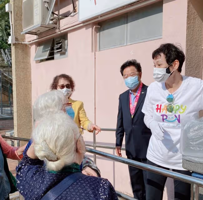 周潤發前妻當志願者,街頭派免費盒飯給老人家,低頭彎腰顯恭敬