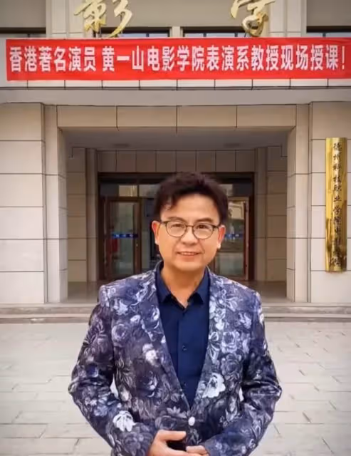 56歲黃一山榮升教授！穿正裝上課學生超喜歡，曾同時接15部電影，創業破產年花千萬只爲救重病仔，如今二仔高大超帥讀名校