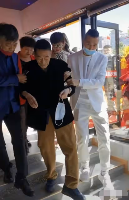 90歲楊少華惹爭議！走路顫巍被架著出席活動，做核酸卻需醫護上門