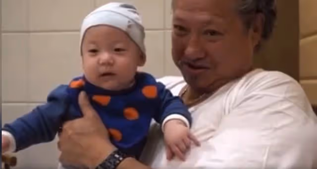 70歲洪金寶抱孫子猛親,惹哭孫子仍不願放手,脖子掛大金鍊太搶眼