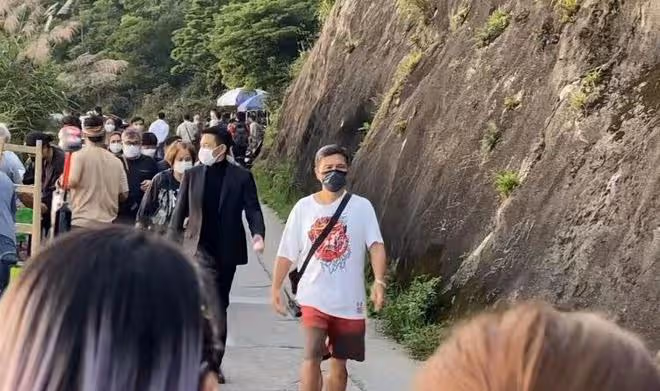 60歲劉德華在山上拍廣告,西裝革履走路帶風,與路人主動揮手