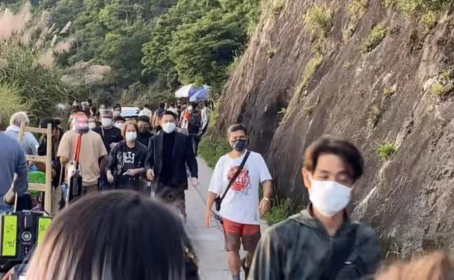 60歲劉德華在山上拍廣告,西裝革履走路帶風,與路人主動揮手