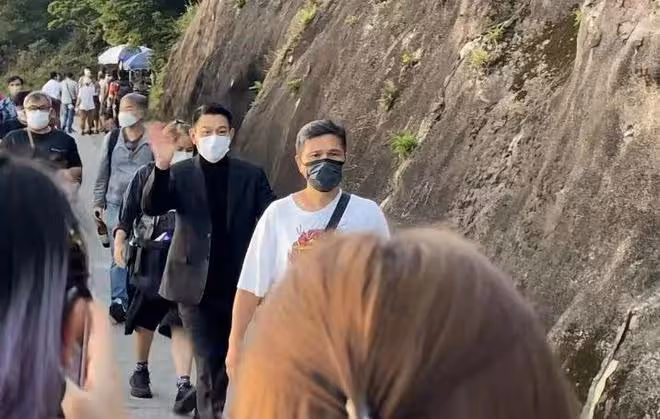 60歲劉德華在山上拍廣告,西裝革履走路帶風,與路人主動揮手