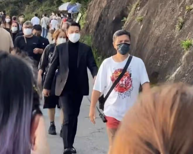 60歲劉德華在山上拍廣告,西裝革履走路帶風,與路人主動揮手