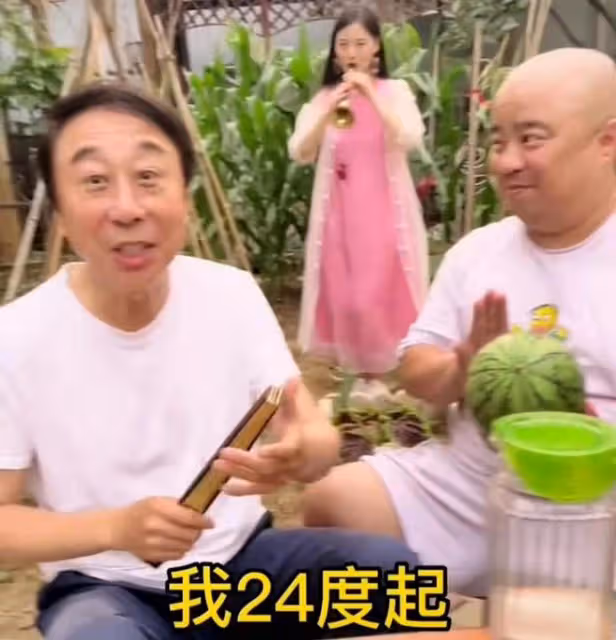 馮鞏攜徒弟送夏至祝福,頭髮稀疏眼紋明顯,身後粉衣女吹嗩吶搶鏡