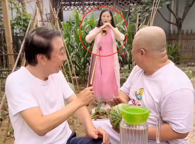 馮鞏攜徒弟送夏至祝福,頭髮稀疏眼紋明顯,身後粉衣女吹嗩吶搶鏡