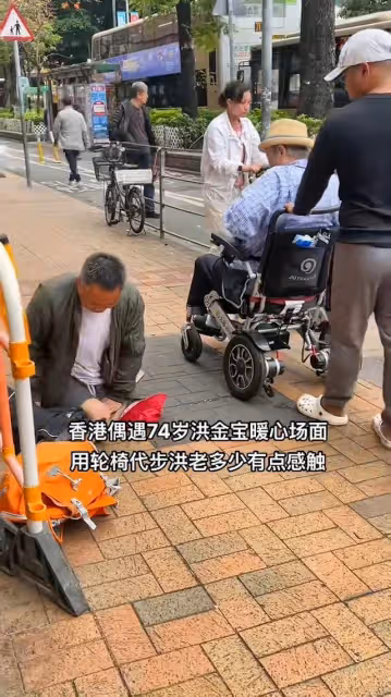 72歲洪金寶坐輪椅給乞丐送錢，親自將500元遞到乞丐手中