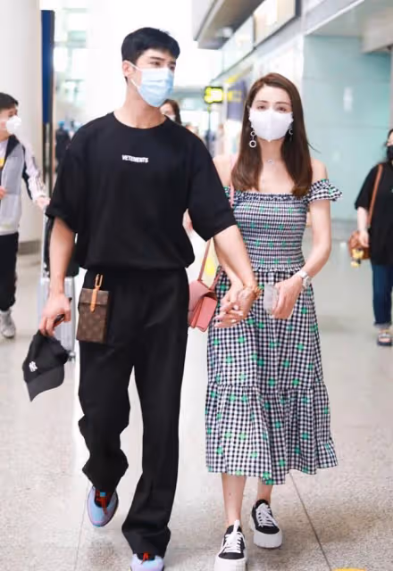 麥迪娜和姜潮出街好恩愛,手挽手並肩走,露肩長裙穿得真挺美