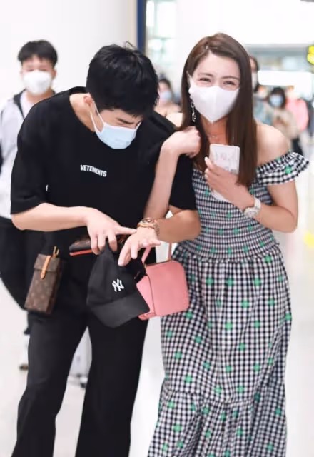 麥迪娜和姜潮出街好恩愛,手挽手並肩走,露肩長裙穿得真挺美