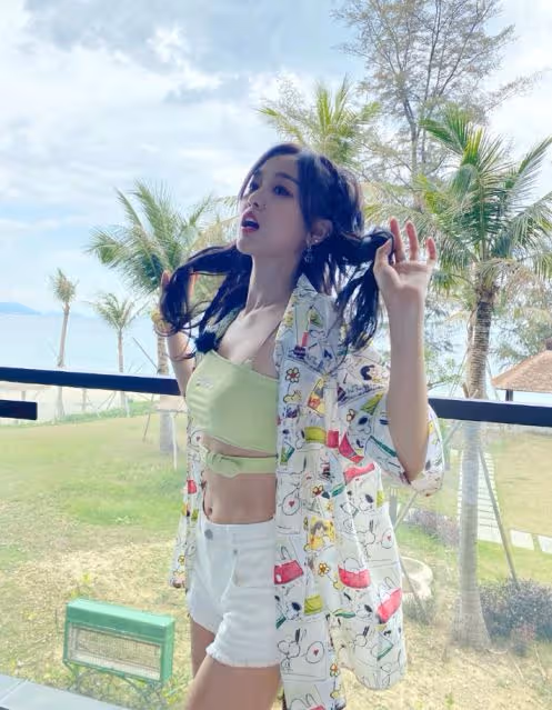 吳宣儀在露台凹造型，穿綠色抹胸秀巴掌腰，牛仔熱褲盡顯火辣身材
