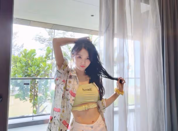 吳宣儀在露台凹造型，穿綠色抹胸秀巴掌腰，牛仔熱褲盡顯火辣身材