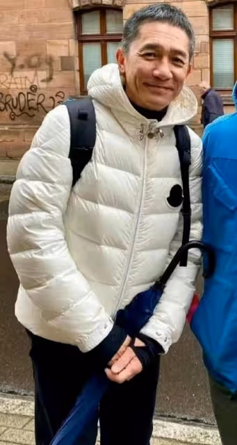 61歲梁朝偉在德國和路人合影，滿頭白髮的他這一次笑得很開心
