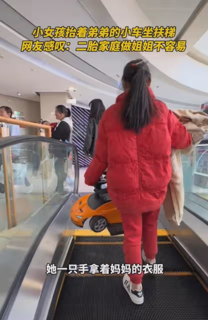 女孩抬著弟弟的車,拿著衣服坐扶梯,網友:二胎家庭做姐姐不容易