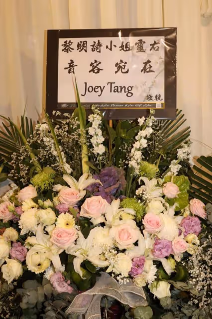 黎明詩葬禮舉行，棺木被擺滿的鮮花圍繞，陳偉霆錢小豪送花籃
