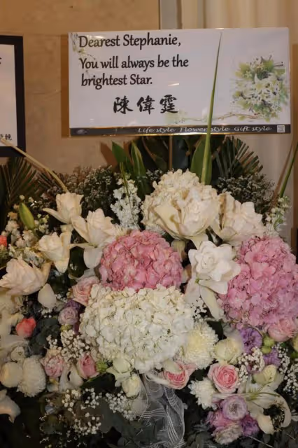 黎明詩葬禮舉行，棺木被擺滿的鮮花圍繞，陳偉霆錢小豪送花籃