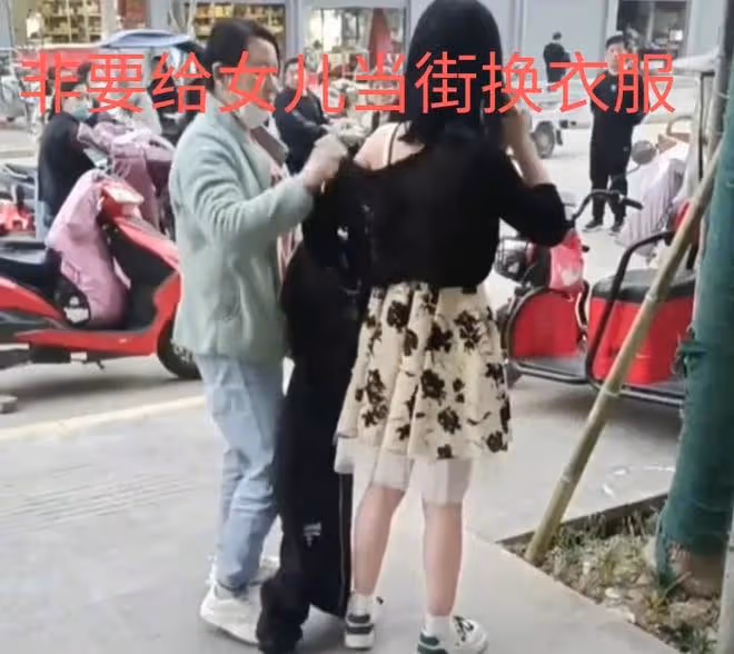 媽媽嫌女兒穿著太暴露，拿著外套追到大街上，非要給女兒換衣服