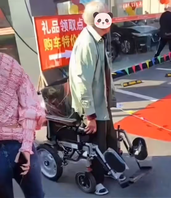 車模在台上表演,坐在輪椅上的大爺離太遠看不清,一著急站了起來