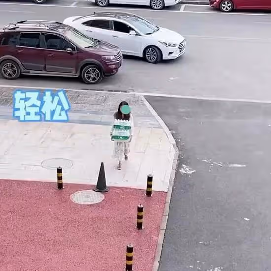 一女子扛兩箱水走在路上很輕鬆,看到哥哥回來,裝手無縛雞之力