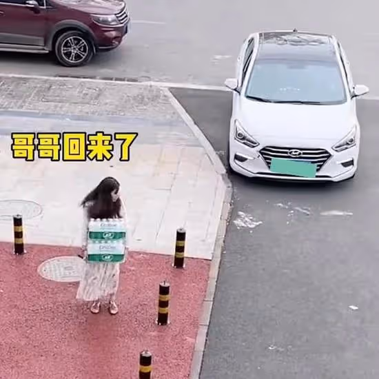 一女子扛兩箱水走在路上很輕鬆,看到哥哥回來,裝手無縛雞之力