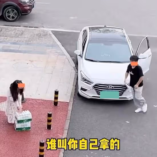 一女子扛兩箱水走在路上很輕鬆,看到哥哥回來,裝手無縛雞之力
