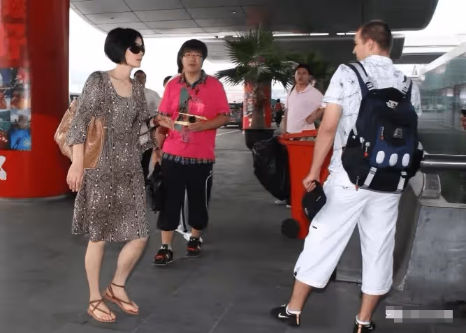 53歲王菲徹底放飛!這打扮懷孕了誰都認不出,穿大媽裙踩人字拖走機場
