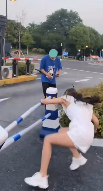 女子跳過警示柱,不料被絆倒在地,警示柱都歪了