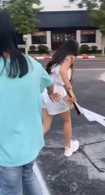 女子跳過警示柱,不料被絆倒在地,警示柱都歪了