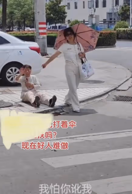 老人摔倒,女子打傘在旁不扶,非要喊路過小哥幫扶:這誰敢去扶?