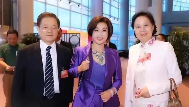 劉曉慶和四婚老公出來應酬！她一襲紫色西裝比老公還氣派，太高調