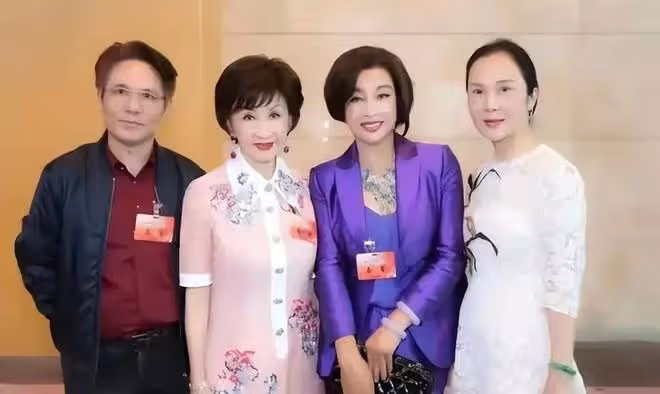 劉曉慶和四婚老公出來應酬！她一襲紫色西裝比老公還氣派，太高調