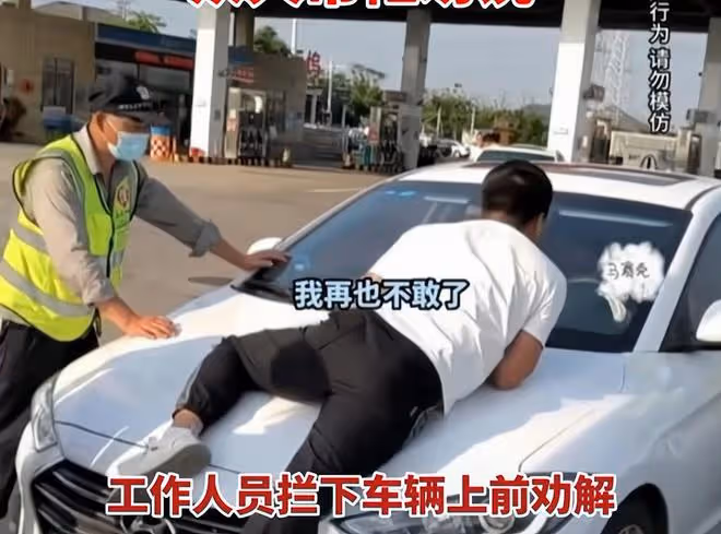 夫妻倆服務區吵架,妻子賭氣要開車上高速,丈夫忙趴引擎蓋上阻攔